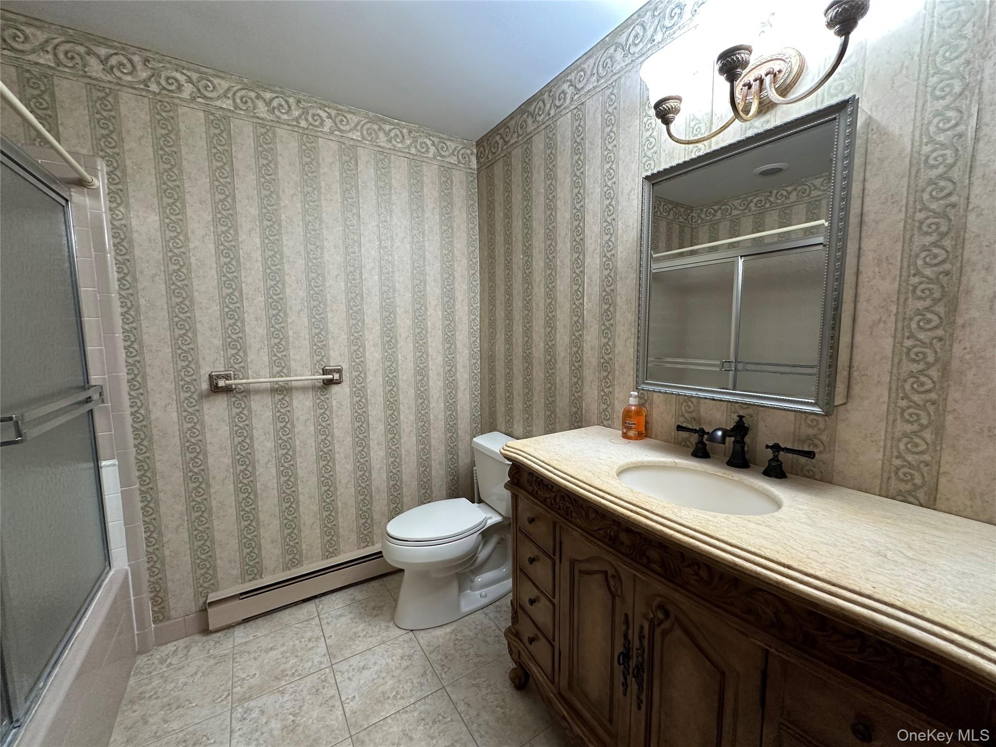 9 Guilford Court, Unit B Ridge, NY 11961 - Photo 10 of 12 a bathroom with a sink a toilet and a mirror