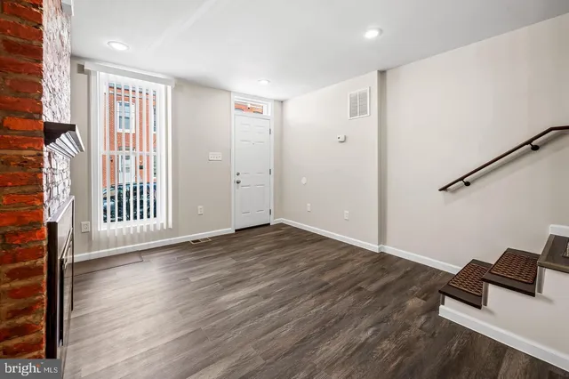 a view of a livingroom with wooden floor and white walls