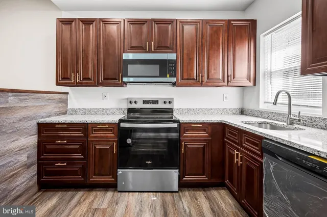 a kitchen with granite countertop a stove and a sink