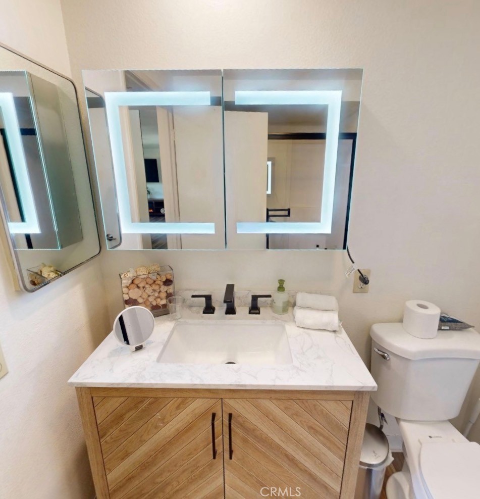 2143 Ronda Granada, Unit O Laguna Woods, CA 92637 - Photo 8 of 33 a bathroom with a toilet sink and mirror