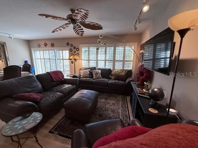 a living room with furniture a ceiling fan and a window