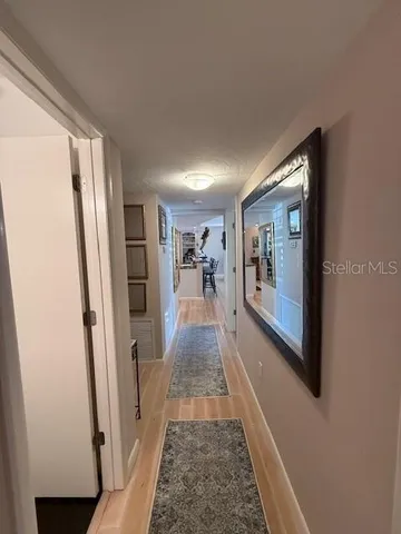 a view of a hallway view with living room and wooden floor