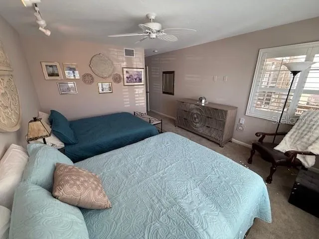 a bedroom with a bed chandelier and a window
