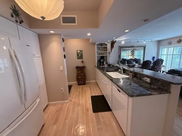 a kitchen with granite countertop a sink stove and refrigerator