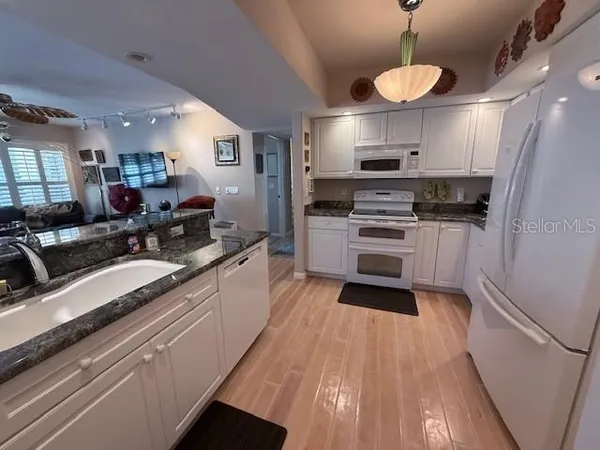 a kitchen with granite countertop a sink stainless steel appliances and counter space