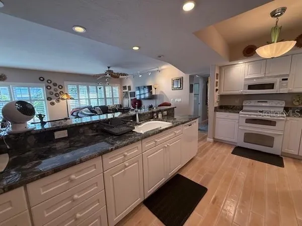 a large kitchen with stainless steel appliances a large counter top a stove and a sink
