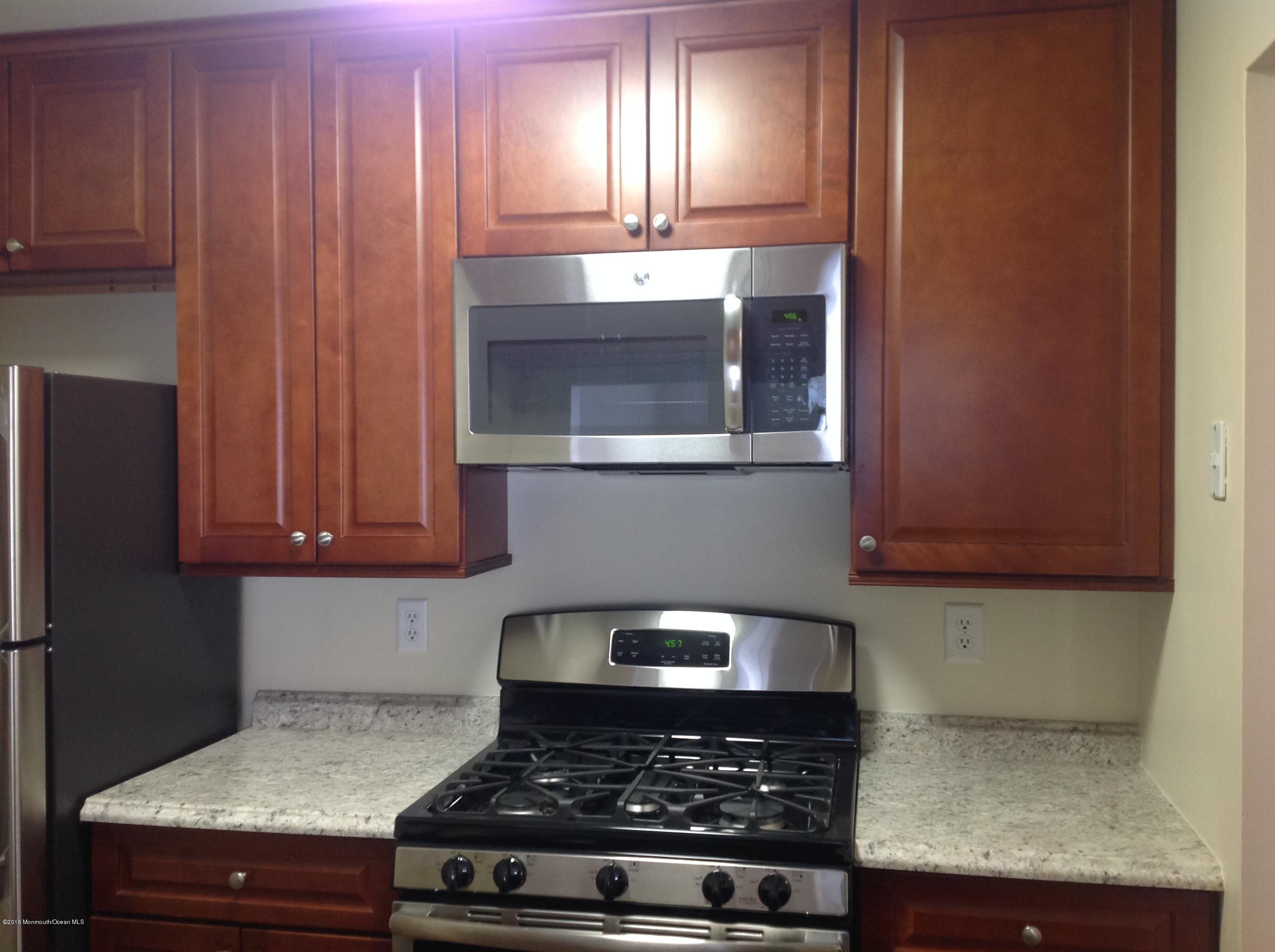 a kitchen with granite countertop stainless steel appliances a stove a microwave and cabinets