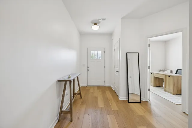 a view of a hallway with wooden floor and staircase