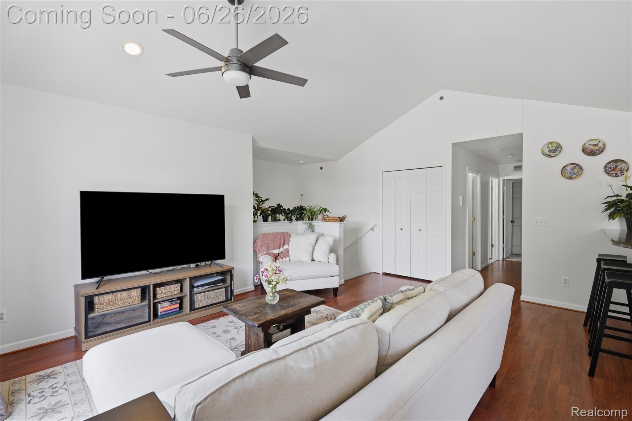 1668 Deepwood Circle Rochester, MI 48307 - Photo 10 of 27 Spacious living area featuring vaulted ceilings, a modern ceiling fan with integrated lighting, wood-finish flooring, and white bi-fold closet doors