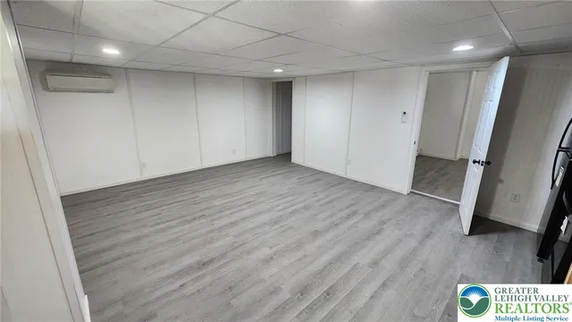 an empty room with wooden floor and mirror