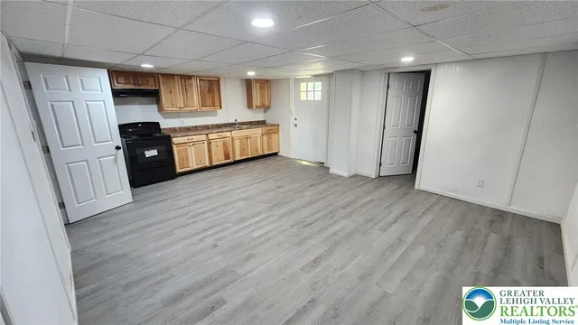 a view of kitchen with refrigerator stove and wooden cabinets