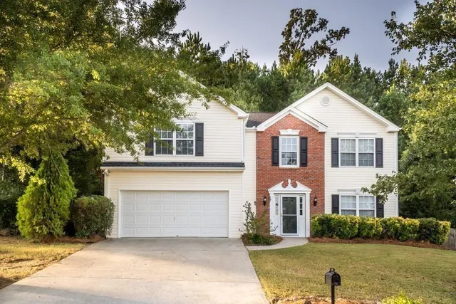 a front view of a house with a garden and garage
