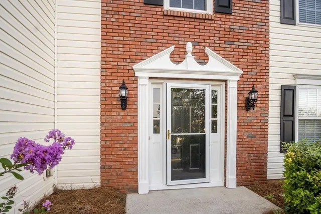 a front view of a house with a potted plant
