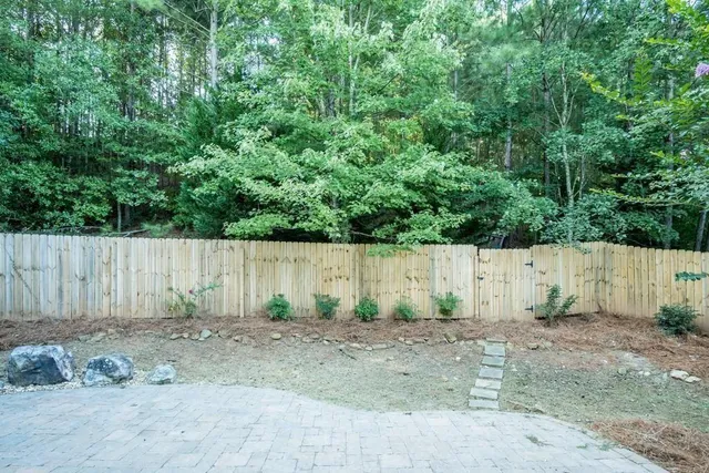 a view of backyard with small play house and trees