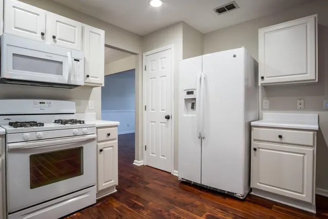 a kitchen with white cabinets and white appliances