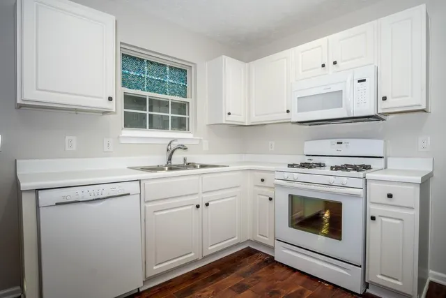 a kitchen with cabinets appliances a sink and a window