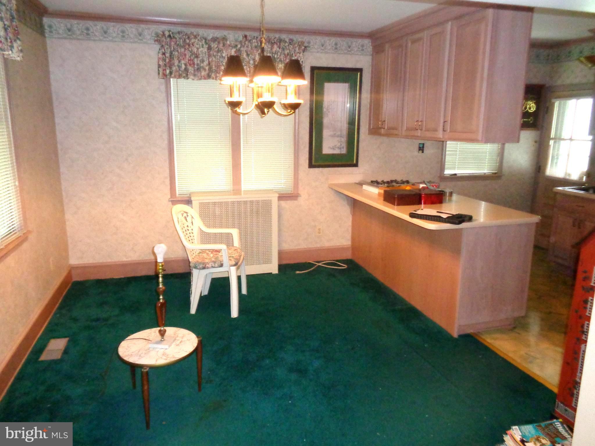 47 Broadship Road Baltimore, MD 21222 - Photo 16 of 27 a kitchen with kitchen island a stove a sink and a dining table with garden view