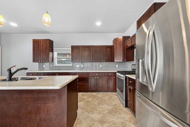 a kitchen with stainless steel appliances granite countertop a sink stove and refrigerator