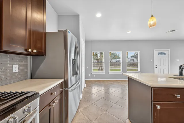 a kitchen with stainless steel appliances granite countertop a refrigerator and a sink