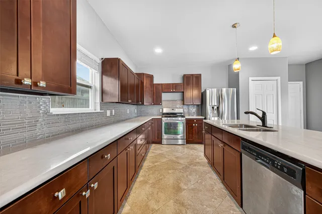 a kitchen with stainless steel appliances a sink stove and cabinets