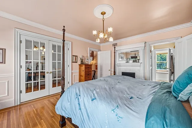 a view of a bedroom with wooden floor and windows