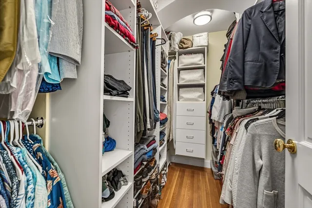 a view of walk in closet with clothes and shoes