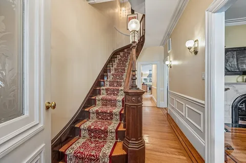 a view of a hallway with wooden floor and staircase
