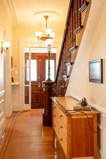a view of a hallway with wooden floor and staircase