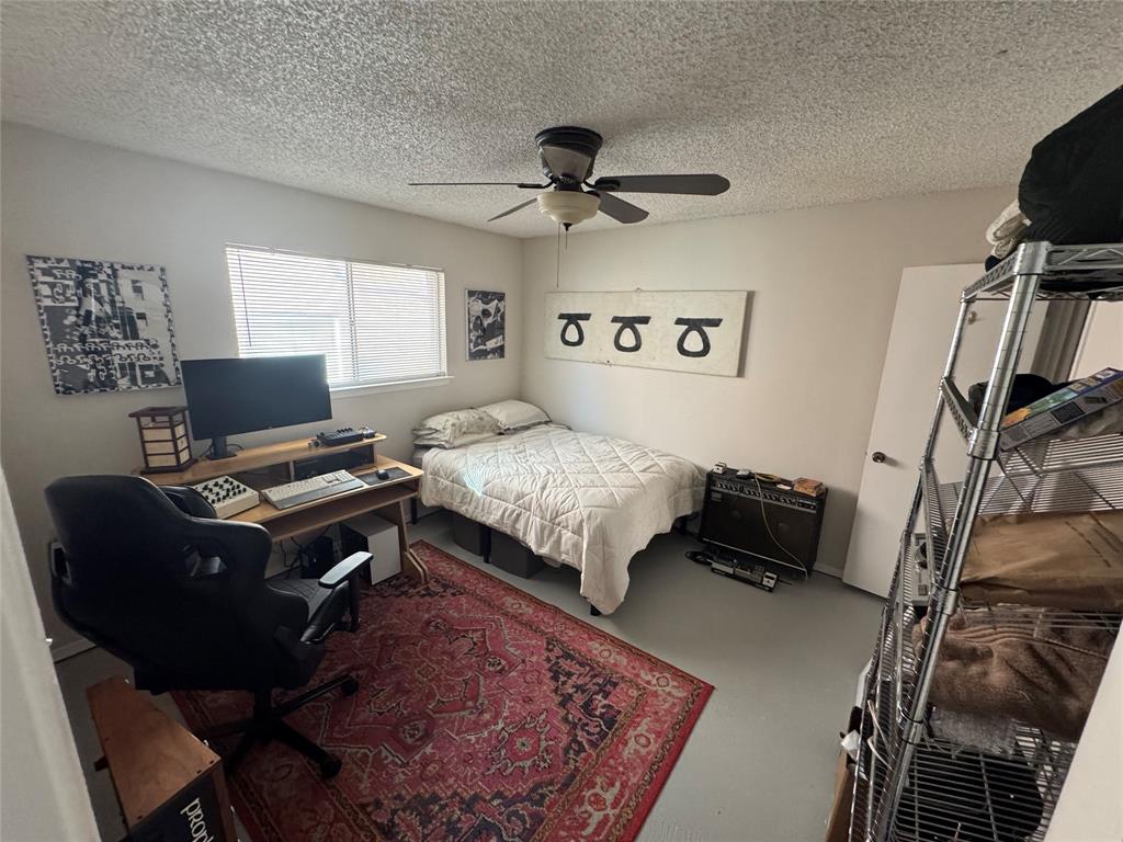 2708 McCart Avenue, Unit 2710 Fort Worth, TX 76110 - Photo 5 of 10 a bedroom with a bed and a desk