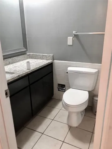 a bathroom with a granite countertop toilet and a sink