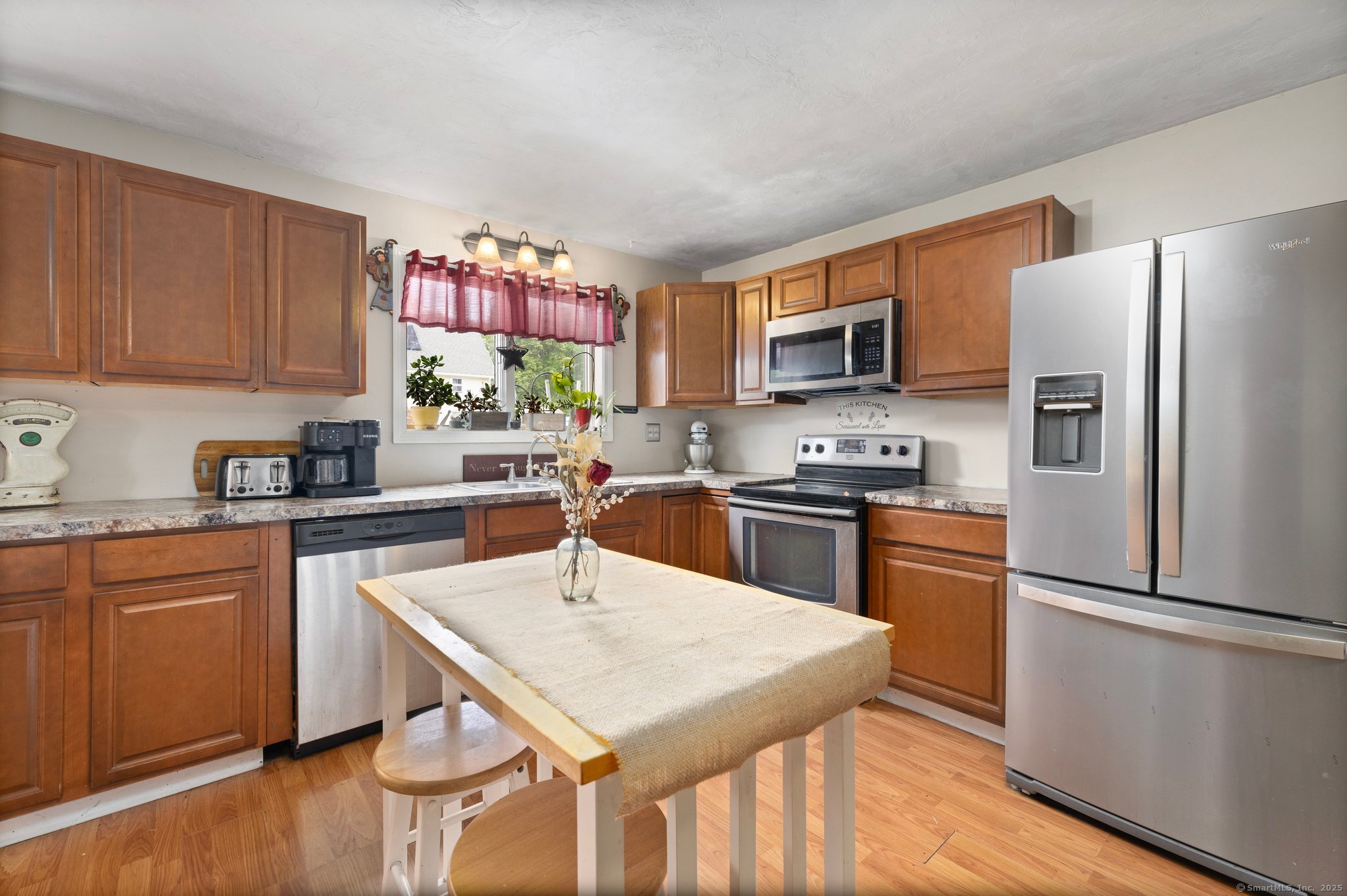 a kitchen with granite countertop stainless steel appliances a refrigerator microwave and stove top oven