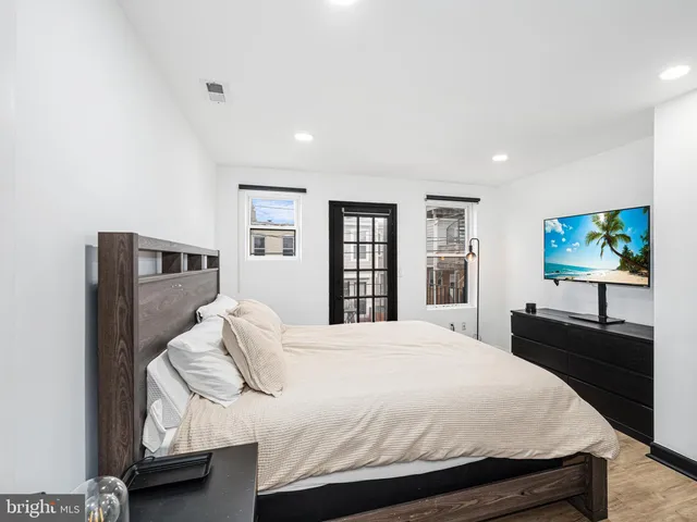 a bedroom with a bed and dresser with mirror