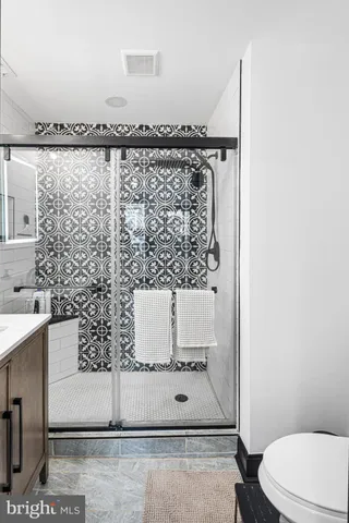 a bathroom with a granite countertop bathtub sink vanity and toilet