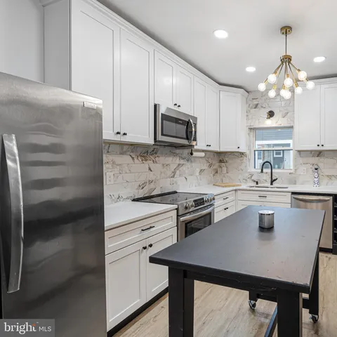 a kitchen with kitchen island a stove microwave and cabinets