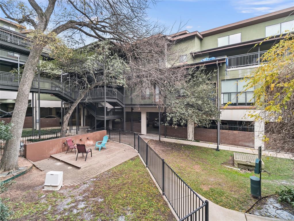 911 Keith Lane, Unit 12 Austin, TX 78705 - Photo 16 of 16 a view of a patio with couches table and chairs with wooden floor and fence