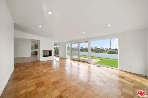 a view of an empty room with a stove and kitchen view