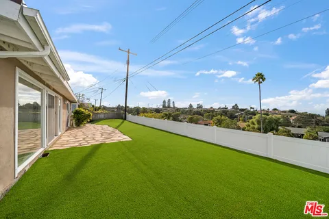 a view of a house with a big yard and potted plants