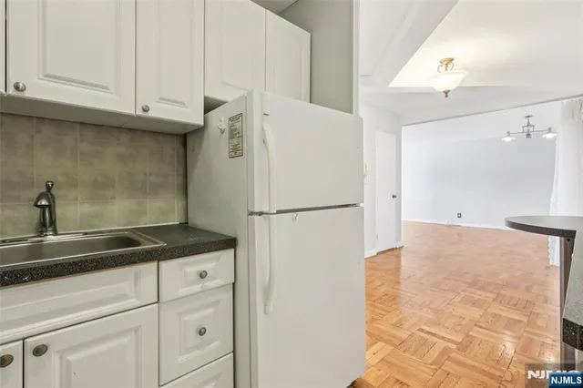 a view of a hallway with furniture and chandelier