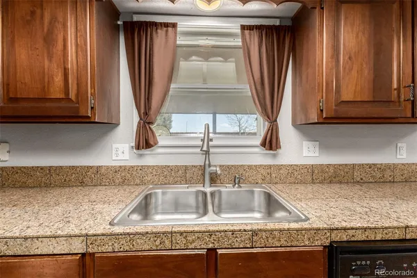 a kitchen with granite countertop a sink and a window