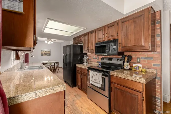 a kitchen with granite countertop a stove sink and microwave