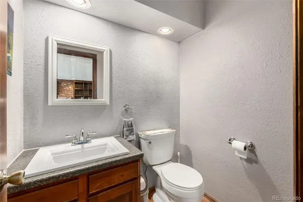 a bathroom with a sink vanity mirror and toilet