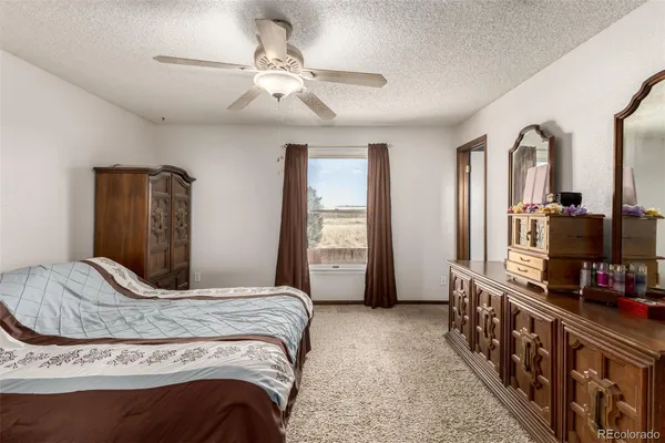 a bedroom with a bed and dresser with mirror