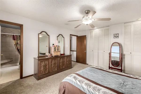 a bedroom with a bed and a mirror on the dresser