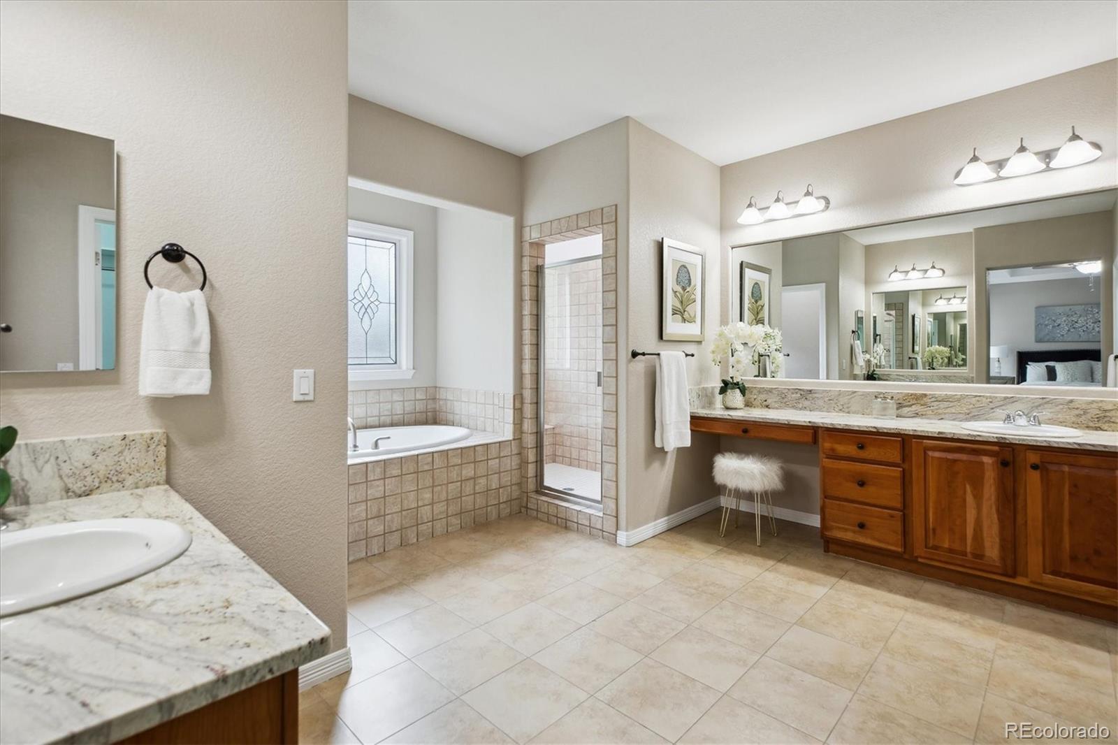 2601 Pemberly Avenue Highlands Ranch, CO 80126 - Photo 20 of 38 a spacious bathroom with a granite countertop tub sink and mirror