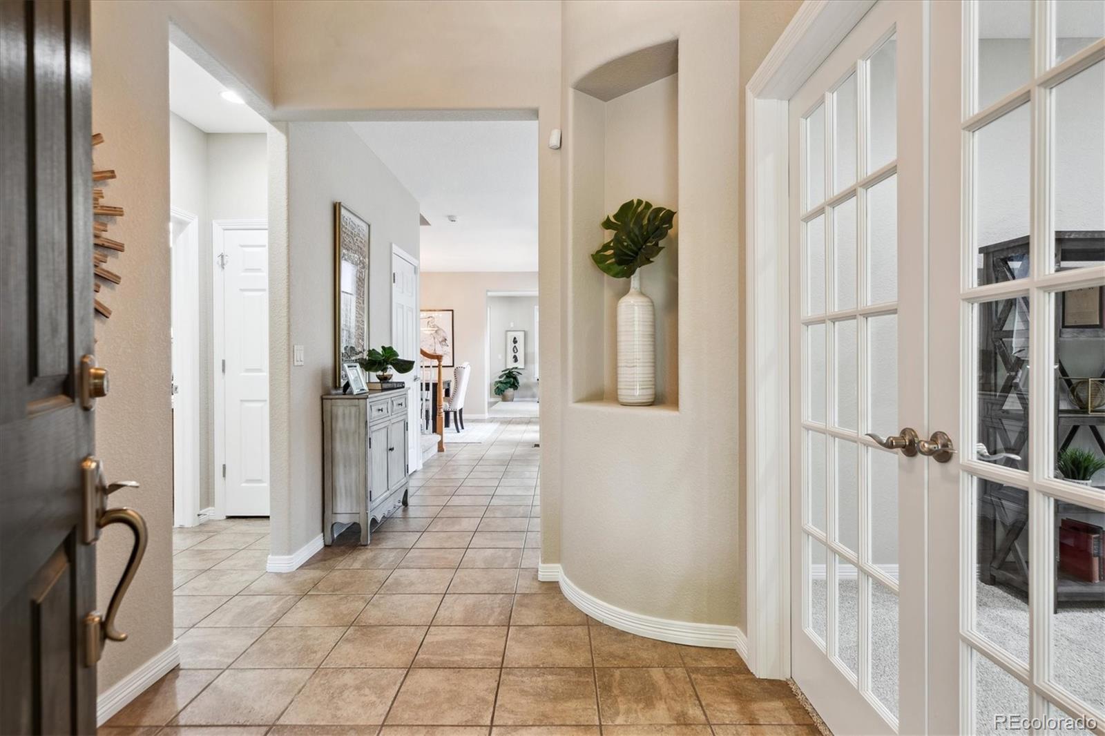2601 Pemberly Avenue Highlands Ranch, CO 80126 - Photo 2 of 38 a view of a hallway with a dining table and a chair
