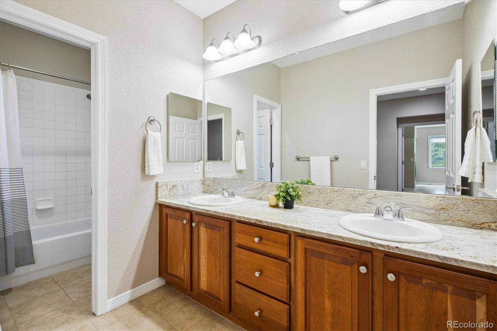 2601 Pemberly Avenue Highlands Ranch, CO 80126 - Photo 24 of 38 a bathroom with a granite countertop sink double and mirror