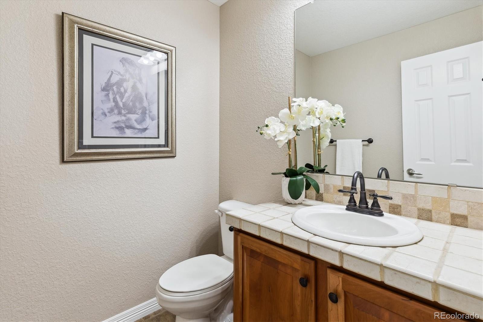 2601 Pemberly Avenue Highlands Ranch, CO 80126 - Photo 28 of 38 a bathroom with a granite countertop sink mirror and toilet