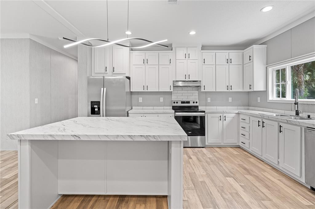 375 Sapp Street Inglis, FL 34449 - Photo 11 of 36 a kitchen with stainless steel appliances kitchen island a white cabinets and sink