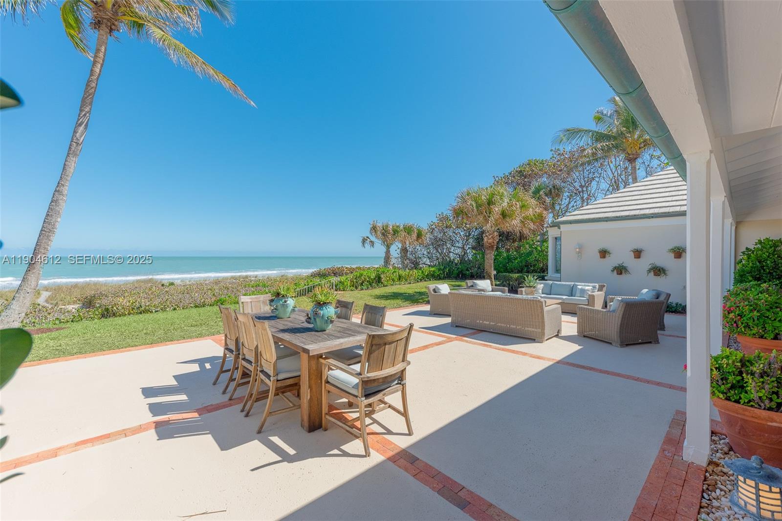 247 South Beach Road Jupiter Island, FL 33455 - Photo 28 of 71 a view of a patio with lawn chairs floor to ceiling window and an outdoor space