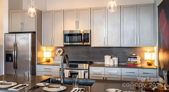 a kitchen with stainless steel appliances granite countertop a refrigerator stove and sink